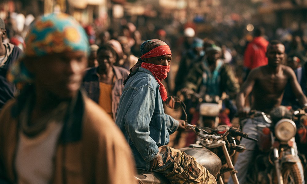 Candid documentary view of Kenyan youth on motorcycles during political street mobilization ahead of elections